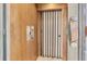 Home elevator with unique door, wood-paneled walls, and vintage-style controls at 700 126Th Ave, Treasure Island, FL 33706