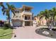 Beautiful three-story home with multiple balconies, a spiral staircase, and lush tropical landscaping at 700 126Th Ave, Treasure Island, FL 33706