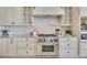 Close-up view of the gourmet kitchen features a stainless-steel stove, custom cabinets, and granite counters at 700 126Th Ave, Treasure Island, FL 33706