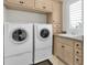 Bright laundry room with front load washer and dryer, storage cabinets and granite countertop at 700 126Th Ave, Treasure Island, FL 33706