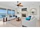 Bright living room features neutral tones, a fireplace, and expansive windows with a lovely water view at 700 126Th Ave, Treasure Island, FL 33706