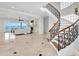 Open-concept living room features a curved staircase, and expansive windows with water views at 700 126Th Ave, Treasure Island, FL 33706