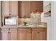 This wet bar features wood cabinets, granite counters, a sink, and a microwave at 700 126Th Ave, Treasure Island, FL 33706