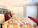 Bright bedroom featuring a colorful floral bedspread, large closets, and ample natural light at 700 Starkey Rd # 821, Largo, FL 33771