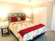Well-lit bedroom features a patterned bedspread, sleek black headboard, and minimalist bedside tables at 700 Starkey Rd # 821, Largo, FL 33771
