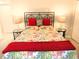 Cozy bedroom setup with bright floral bedspread, red throw, and side tables with decorative lamps at 700 Starkey Rd # 821, Largo, FL 33771