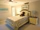 Relaxing bedroom featuring beach artwork and a cute teddy bear on the neatly made bed at 700 Starkey Rd # 821, Largo, FL 33771