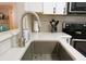 Close-up of a modern kitchen sink with stainless steel fixtures and white countertops at 700 Starkey Rd # 821, Largo, FL 33771