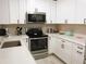 Well-lit kitchen featuring stainless steel appliances, white cabinets, and quartz countertops at 700 Starkey Rd # 821, Largo, FL 33771
