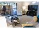 Comfortable living room featuring a sunroom, a television, and a striped chair at 700 Starkey Rd # 821, Largo, FL 33771