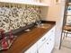 Close up of modern wet bar featuring a stainless-steel sink, unique backsplash, and dark countertop at 700 Starkey Rd # 821, Largo, FL 33771