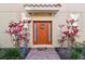 Inviting front door with colorful wreath, sidelights, and tropical landscaping at 8747 Terracina Lake Dr, Tampa, FL 33625