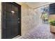 A covered entrance with a black front door, stone pavers, and textured stucco wall offers an inviting welcome at 107 S Obrien St # 117, Tampa, FL 33609