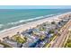 Aerial view of beachfront condos and ocean featuring pool, palm trees, beach access and nearby highway at 108 24Th St, Belleair Beach, FL 33786