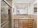 Well-lit bathroom boasting a granite countertop, warm-toned tiled walls and a glass-enclosed shower at 108 24Th St, Belleair Beach, FL 33786