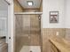 Bathroom featuring tiled walls, glass enclosed shower and a vanity with granite countertop at 108 24Th St, Belleair Beach, FL 33786