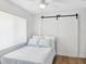Cozy bedroom with a double bed and bright window featuring natural light and a sliding barn door at 108 24Th St, Belleair Beach, FL 33786