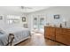 Light and airy bedroom featuring wood floors, a ceiling fan, and bright white walls, complemented by sunny french doors at 108 24Th St, Belleair Beach, FL 33786