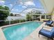 Inviting screened in pool with ample seating, lush landscaping, and clear blue water at 108 24Th St, Belleair Beach, FL 33786