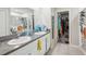 Bright bathroom featuring dual sinks with granite counters, tile floors, and a walk-in closet at 11218 Sage Canyon Dr, Riverview, FL 33578
