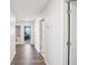 Hallway with wood floors, white walls, and view of bathroom and office at 11218 Sage Canyon Dr, Riverview, FL 33578