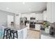 Bright kitchen featuring white cabinets, stainless steel appliances, and a granite-topped island with seating at 11218 Sage Canyon Dr, Riverview, FL 33578