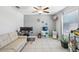 This open space features tile flooring, a couch, multiple computer setups, and a ceiling fan at 11218 Sage Canyon Dr, Riverview, FL 33578