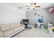 This open space features tile flooring, a couch, multiple computer setups, and a ceiling fan at 11218 Sage Canyon Dr, Riverview, FL 33578