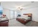 Carpeted main bedroom with a ceiling fan, dresser, and a wooden bed frame at 11218 Sage Canyon Dr, Riverview, FL 33578