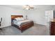 Comfortable carpeted main bedroom with a ceiling fan and a wooden bed frame at 11218 Sage Canyon Dr, Riverview, FL 33578
