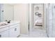 Modern bathroom with white cabinets, marble floors, glass-enclosed shower, and a view into the bedroom at 11795 Starbright Path, Venice, FL 34293