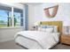 Bright bedroom showcasing a bed with a yellow headboard, a bedside table, and natural light at 11795 Starbright Path, Venice, FL 34293