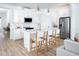 Bright kitchen with white cabinets, stainless steel appliances, an island with bar stools and modern light fixtures at 11795 Starbright Path, Venice, FL 34293