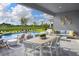 Inviting outdoor patio with dining and lounge area overlooking a sparkling pool and lush greenery at 11795 Starbright Path, Venice, FL 34293