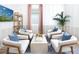 Cozy sitting room with four armchairs arranged around a modern coffee table, decorated with blue pillows and plants at 11795 Starbright Path, Venice, FL 34293