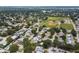 Expansive aerial view of the neighborhood showcasing lush trees, houses, and nearby baseball and soccer fields at 12299 91St N Ave, Seminole, FL 33772