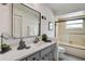 Updated bathroom featuring a vanity with gray cabinets, white countertop and glass enclosed tub-shower at 12299 91St N Ave, Seminole, FL 33772