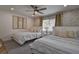 Cozy bedroom with two beds, overhead fan, and wallpaper accent wall, providing a relaxing space at 12299 91St N Ave, Seminole, FL 33772