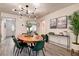Dining room with modern light fixture, seating for six, wood table and gray floors at 12299 91St N Ave, Seminole, FL 33772