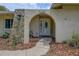 Close-up of the arched front entryway, showcasing stone details and a decorative glass front door with house number at 12299 91St N Ave, Seminole, FL 33772