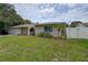 Inviting exterior of a home with lush green lawn, stone detailing, a front-facing garage, and a fenced yard at 12299 91St N Ave, Seminole, FL 33772