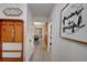 Hallway with gray floors, a coat rack, and view into the dining room at 12299 91St N Ave, Seminole, FL 33772