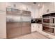 Spacious kitchen featuring stainless steel refrigerator, double oven, and white cabinetry at 12299 91St N Ave, Seminole, FL 33772