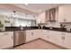 Bright kitchen with white cabinets, stainless steel appliances, and modern lighting fixtures at 12299 91St N Ave, Seminole, FL 33772