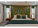 A primary bedroom featuring a decorative green headboard, natural light, and stylish bedding at 12299 91St N Ave, Seminole, FL 33772