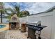 Outdoor kitchen features a built in pizza oven and stainless steel grill on a brick patio at 12299 91St N Ave, Seminole, FL 33772
