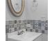 Bathroom featuring black and white mosaic tiles behind a white sink with an ornate mirror at 12720 Four Oaks Rd, Tampa, FL 33624