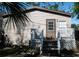 Charming home featuring a front porch with white railings, a brown door, and light beige siding at 12720 Four Oaks Rd, Tampa, FL 33624