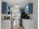 Kitchen featuring granite counters, stainless steel appliances, and blue upper and white lower cabinets at 12720 Four Oaks Rd, Tampa, FL 33624