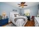 Well-lit bedroom featuring a bed, dresser, ceiling fan, and hardwood floors at 1335 Lahara Way, Trinity, FL 34655